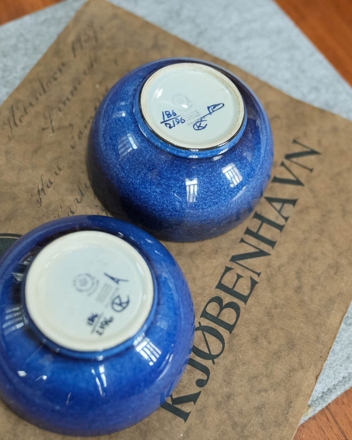 Each base carries Kari Christensen's KC monogram, the Royal Copenhagen three waves and the numbers 186/2196. The painter's initials differ between the two bowls.