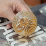 Base of the Kosta Boda miniature vase held in a hand, showing the polished pontil and the feathered stripes