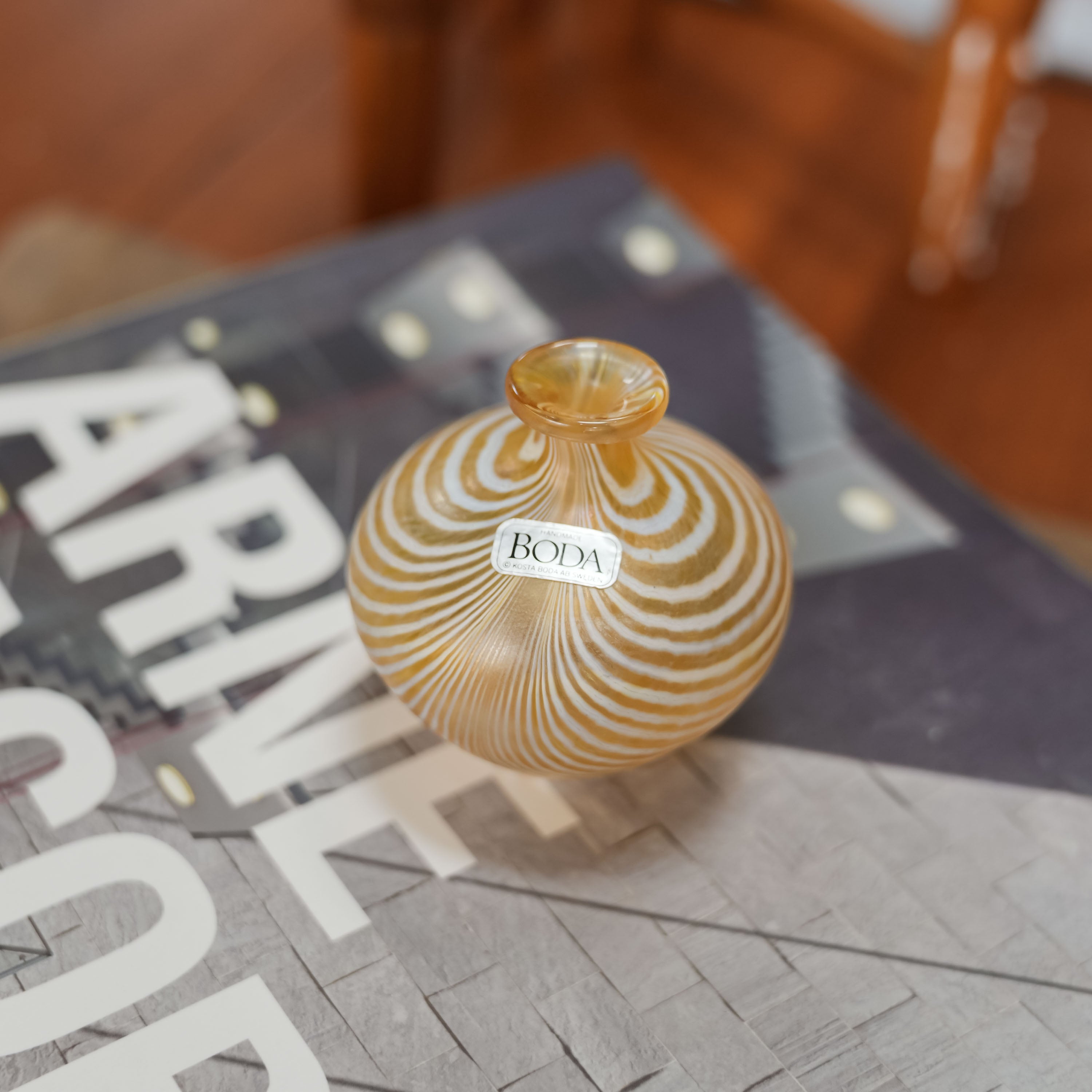 Bertil Vallien for Kosta Boda iridescent miniature vase on a book, gold glass with white pulled-feather stripes