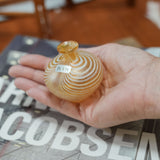 Kosta Boda miniature vase resting in an open palm for scale