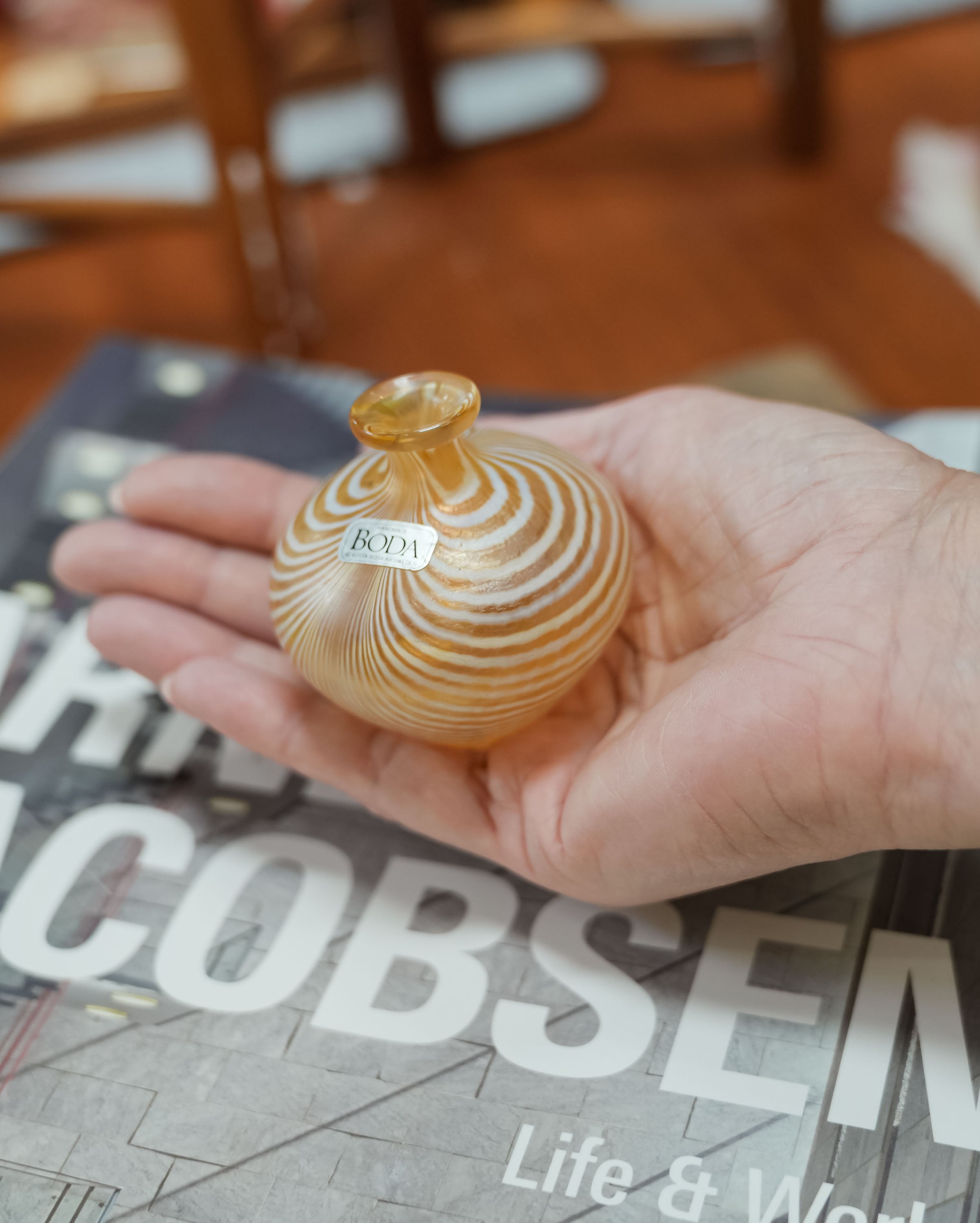 Kosta Boda miniature vase resting in an open palm for scale