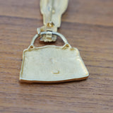 JJ articulated purse brooch, close view of the mark and material