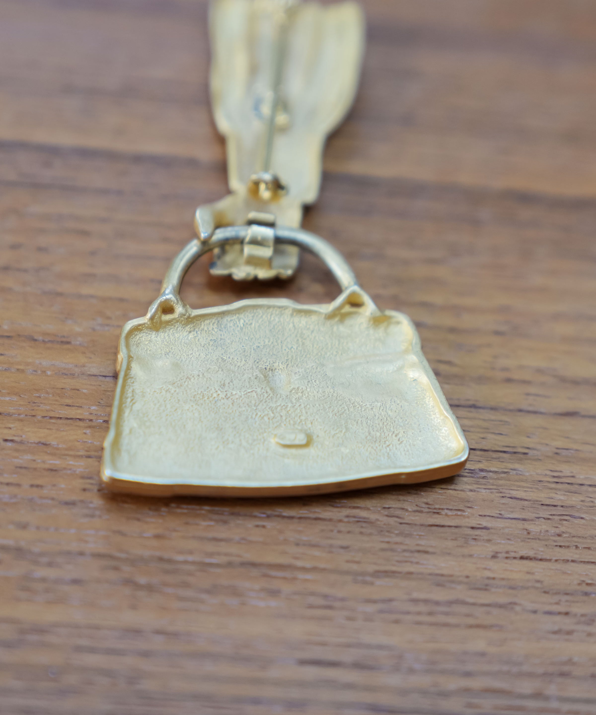 JJ articulated purse brooch, close view of the mark and material