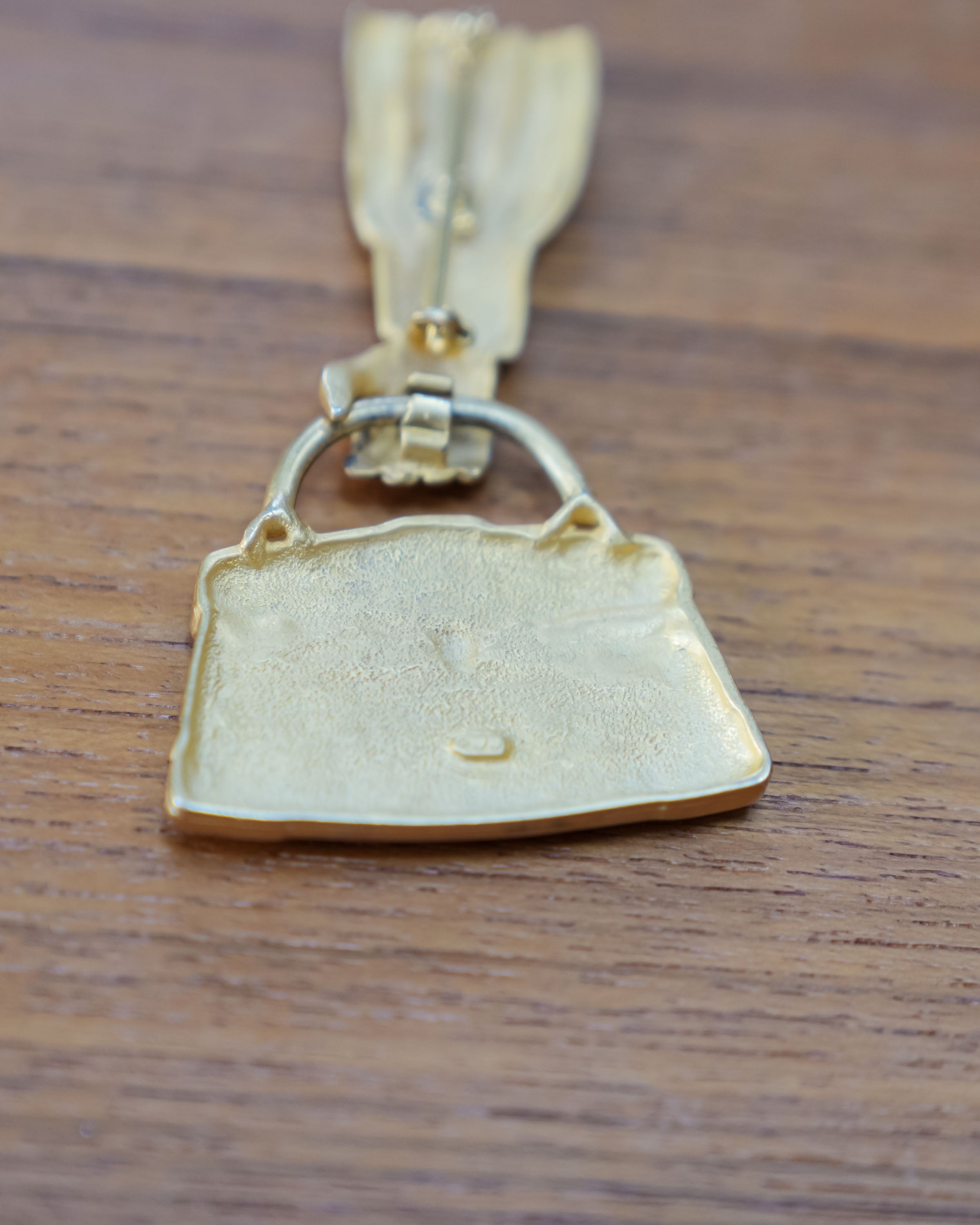 JJ articulated purse brooch, close view of the mark and material