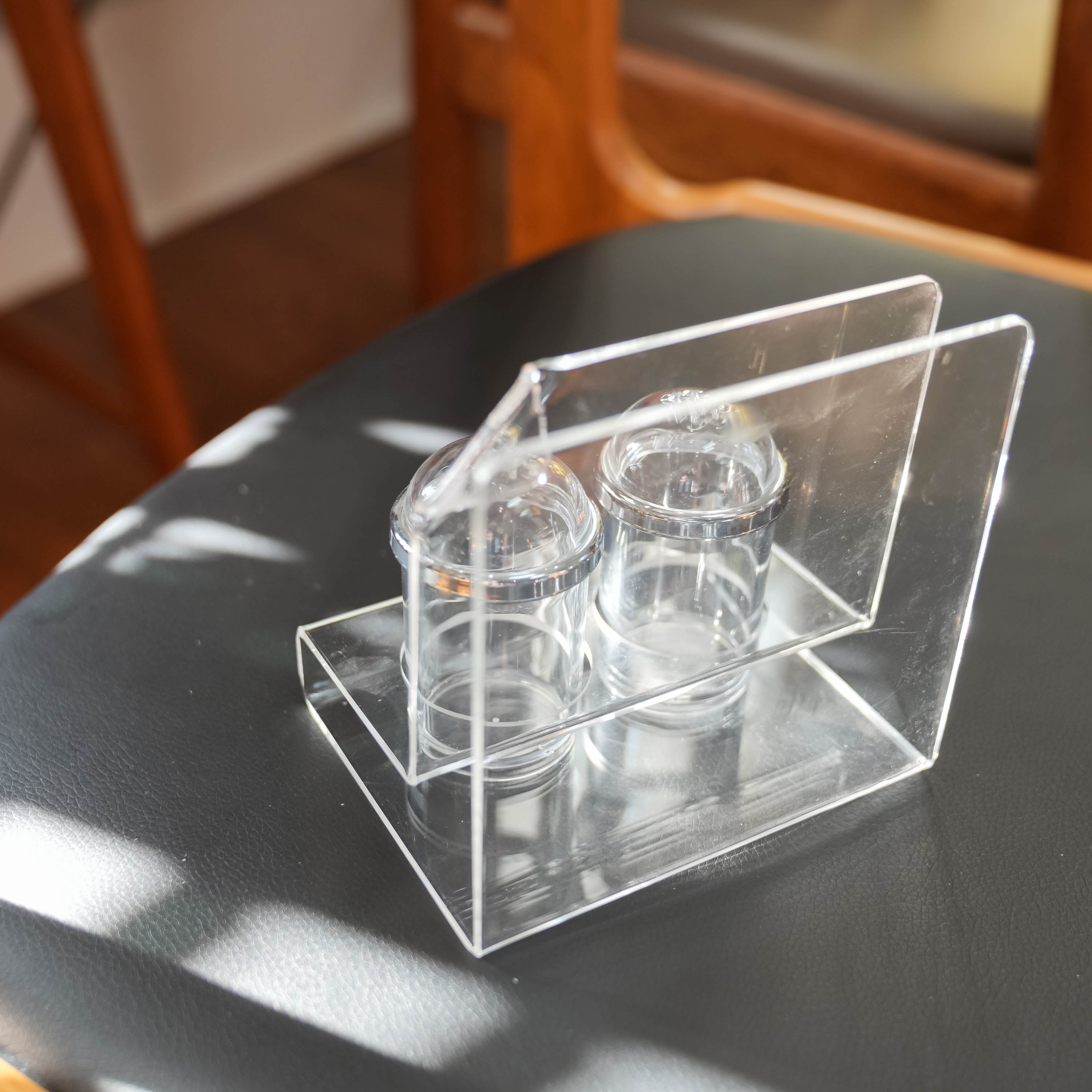 Acrylic salt and pepper shakers with napkin holder, in context on the table