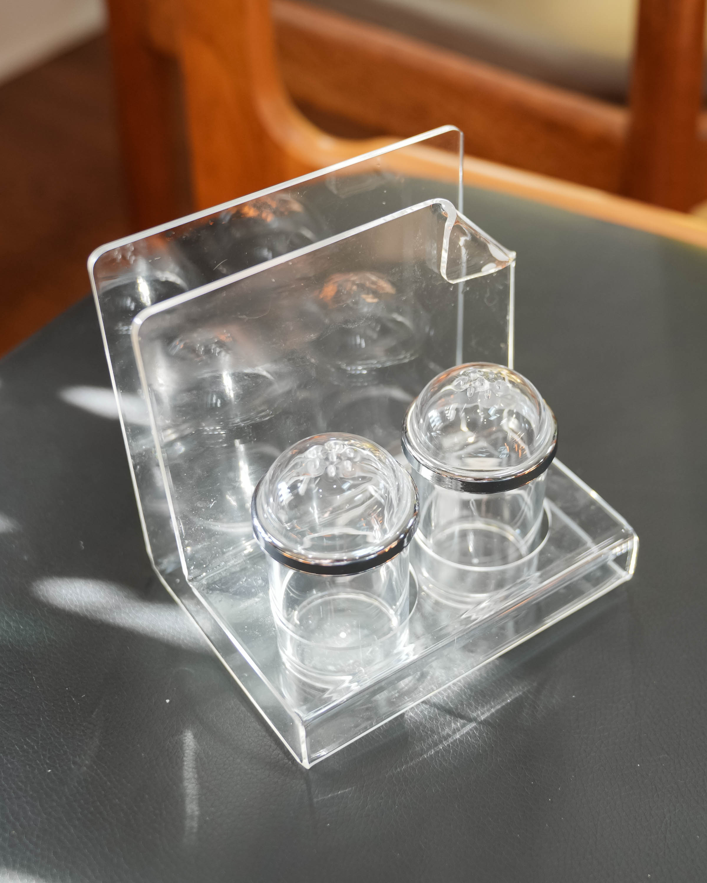 Acrylic salt and pepper shakers with napkin holder, in use