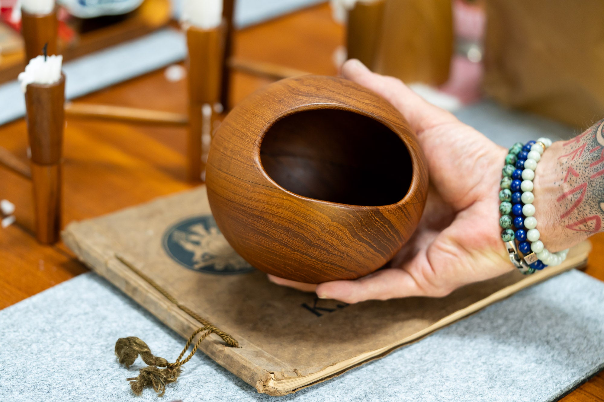 Söwe Konst teak orb nut bowl held in a hand for scale