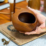 Söwe Konst teak orb nut bowl held in a hand for scale